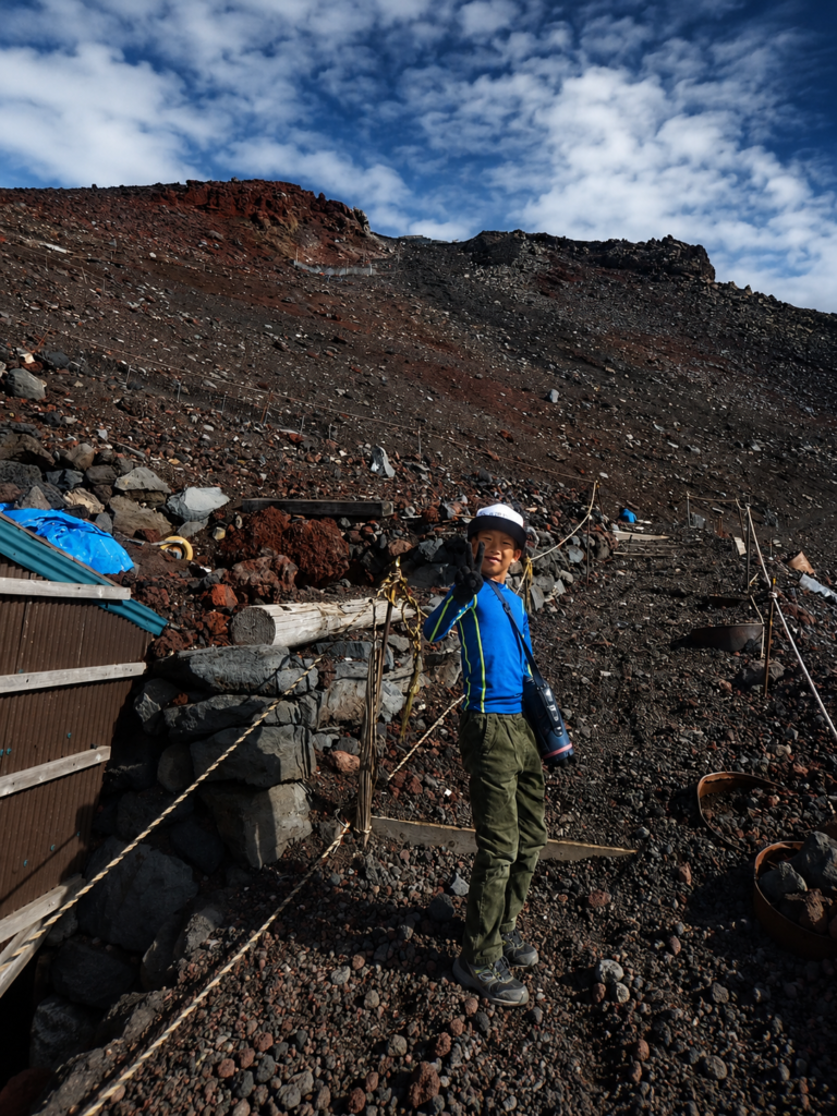 富士山の広大な火山斜面に挑み、振り返る子どもの力強い登山風景|FooWn Camp 富士山1泊2日登山プログラム